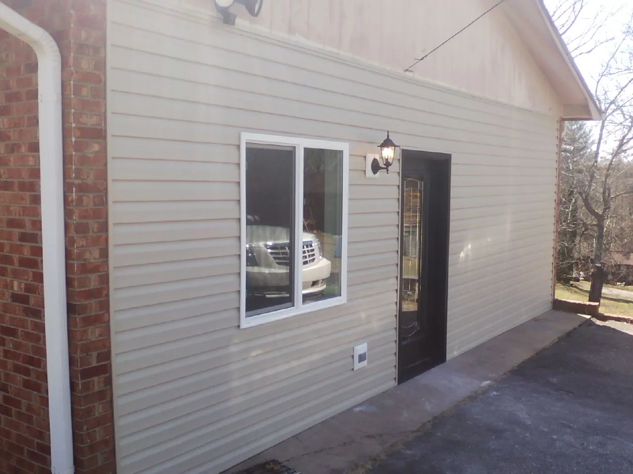 New vinyl siding and entry door on a room addition in Oxford Junction