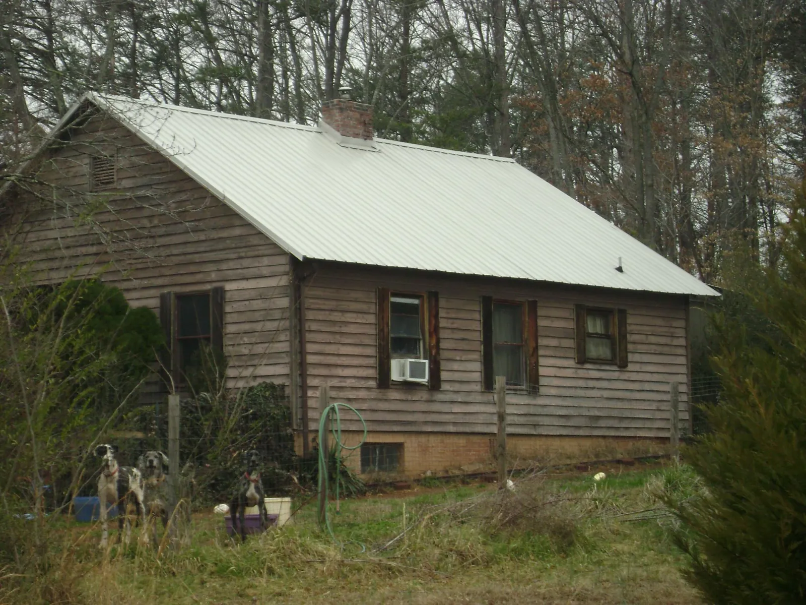 White metal roof on an old wood sided farmhouse, from a Metal Roof Installation job in Oxford Junction